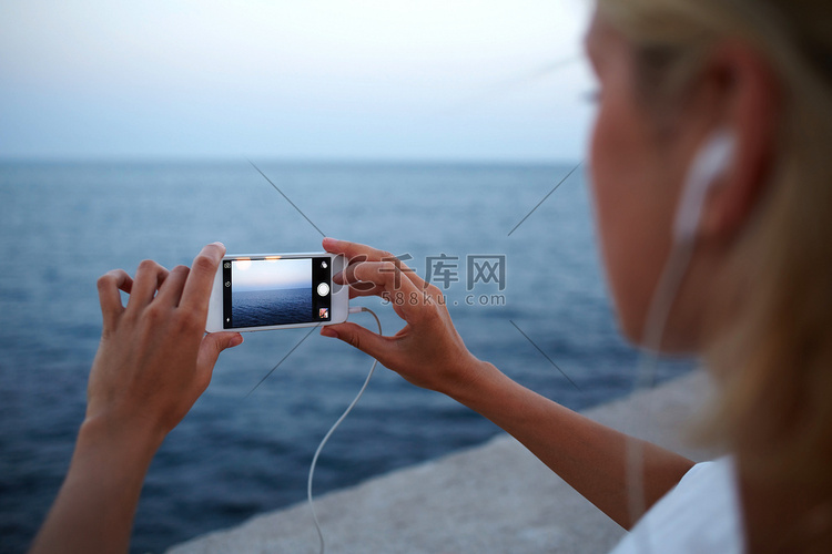 woman taking picture of ocean landscape