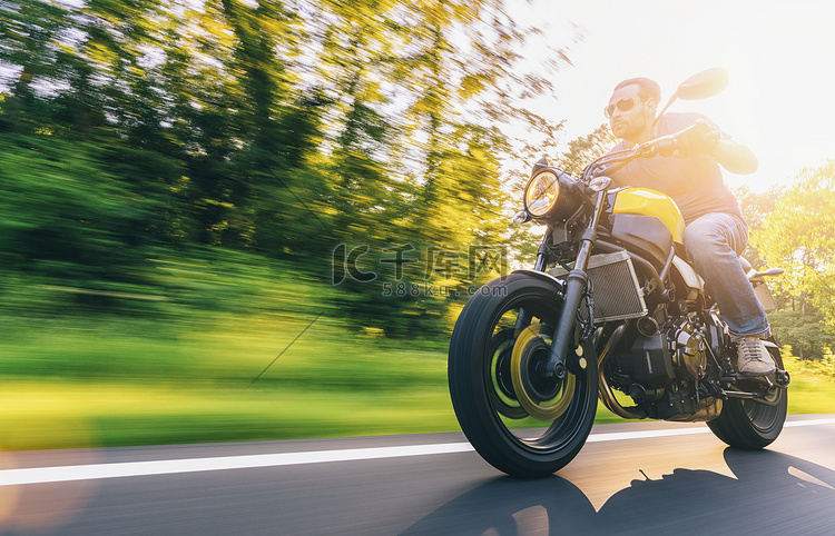 骑摩托车在路上，日落时骑摩托车