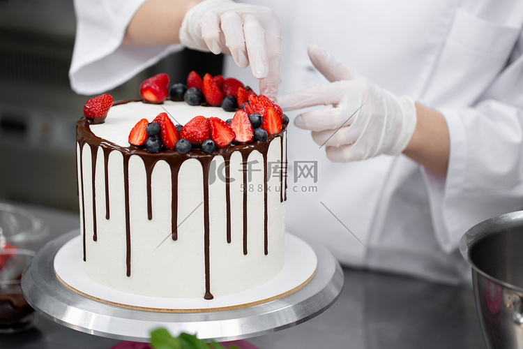 糕点厨师用草莓和蓝莓的巧克力条