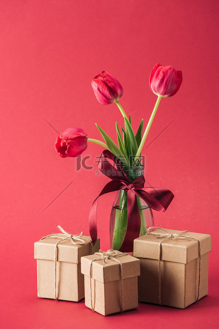 花束红色郁金香与红色缎面碗在玻