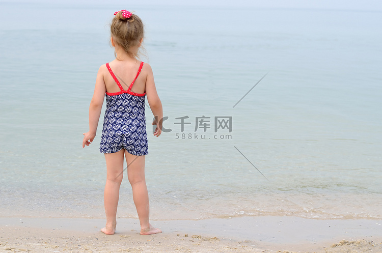小女孩穿着泳衣在海上寻找、 后