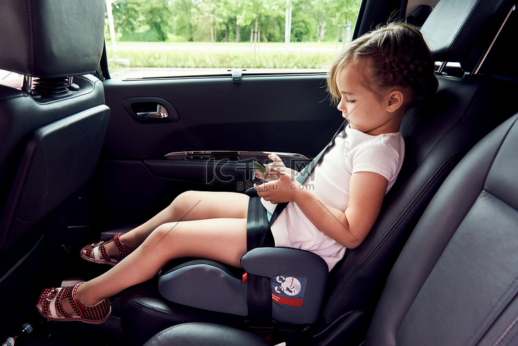 小女孩坐在一辆车，一款智能手机
