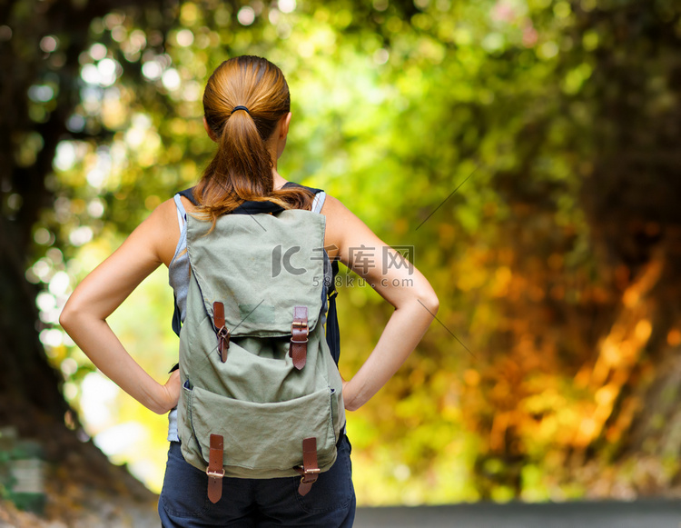 年轻女子背着背包徒步旅行