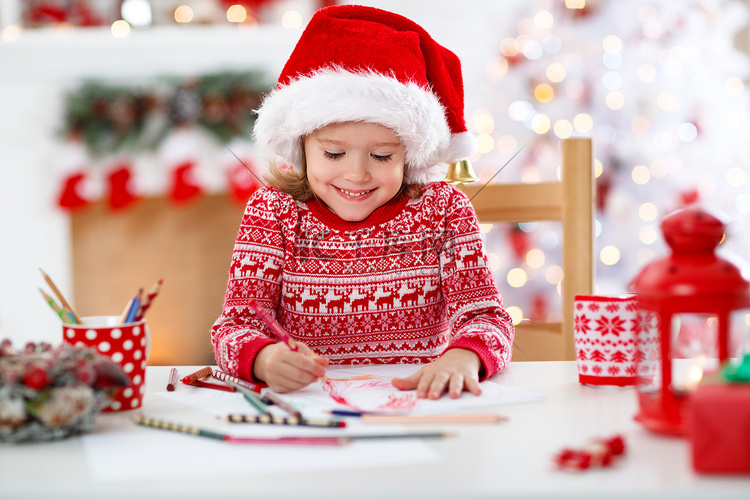 儿童女孩写封信圣家附近的圣诞树