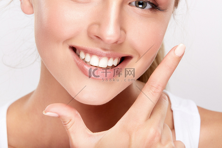 美丽的微笑的妇女显示洁白的牙齿