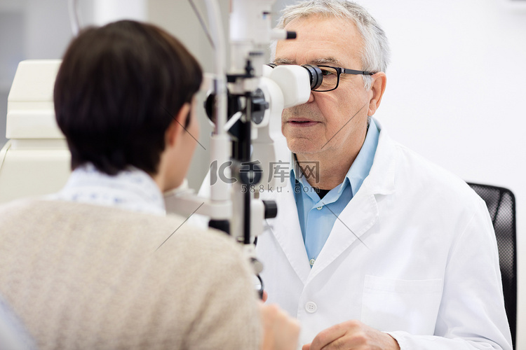 高级眼科专家看在眼底镜和执行眼