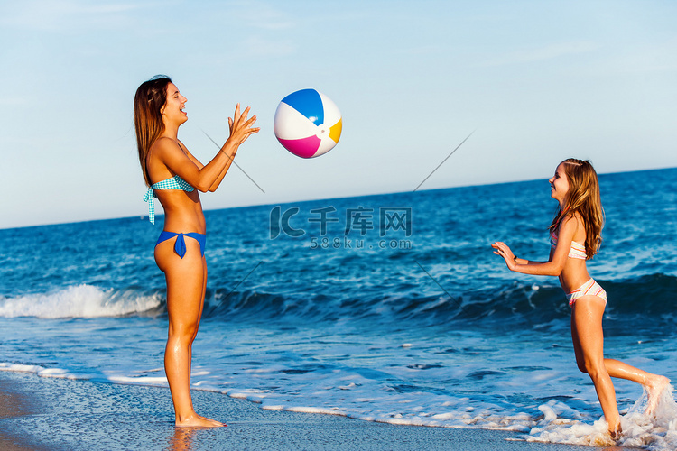 年轻的女孩，在沙滩上玩球.