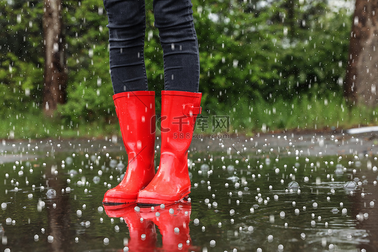 雨天站在户外穿着红色橡胶靴的女