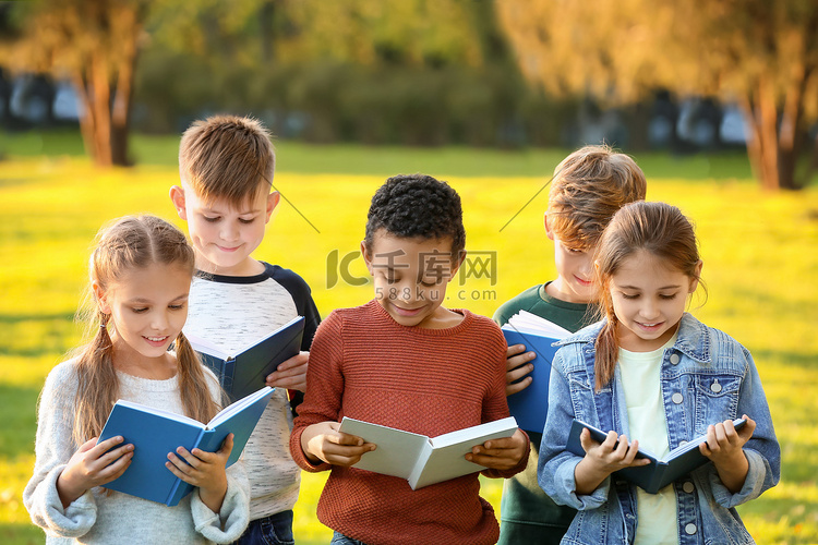可爱的小孩子在公园看书