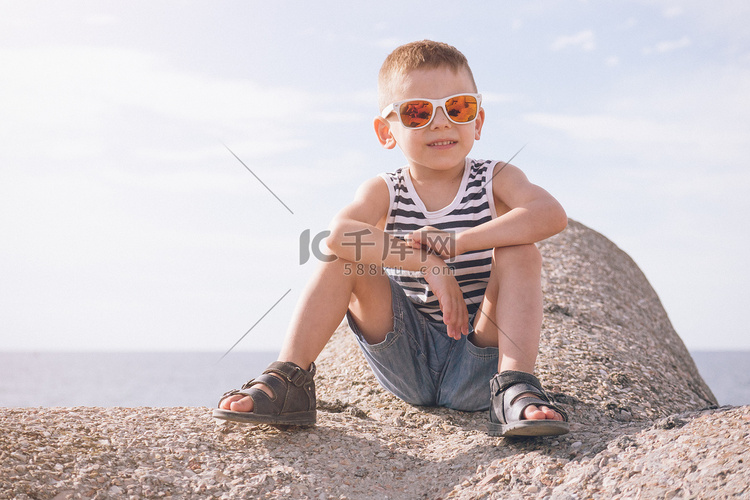 太阳镜的大海背景上的男孩