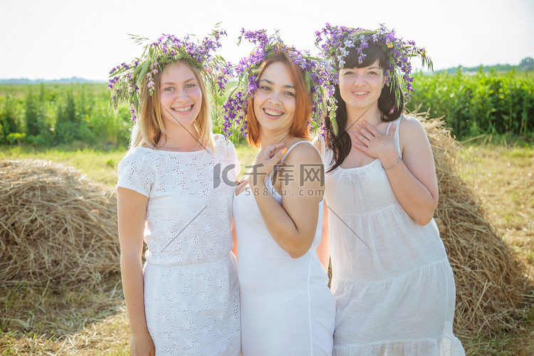 三个年轻漂亮的姑娘在白色礼服和
