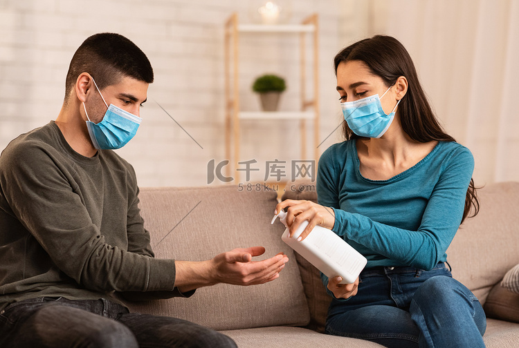夫妻二人坐在沙发上使用抗菌喷雾