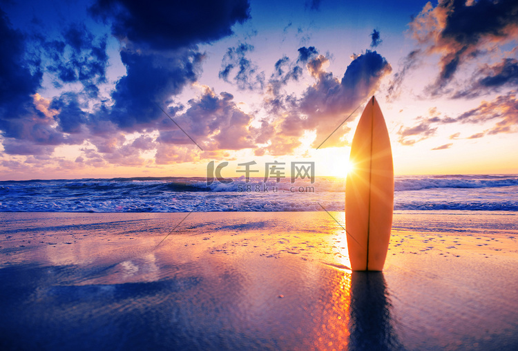 日落时海滩上的冲浪板