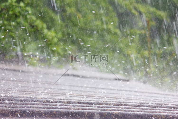 夏天的雨和冰雹落在石板的屋顶上