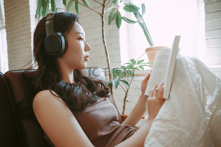 年轻女人在家听音乐看书