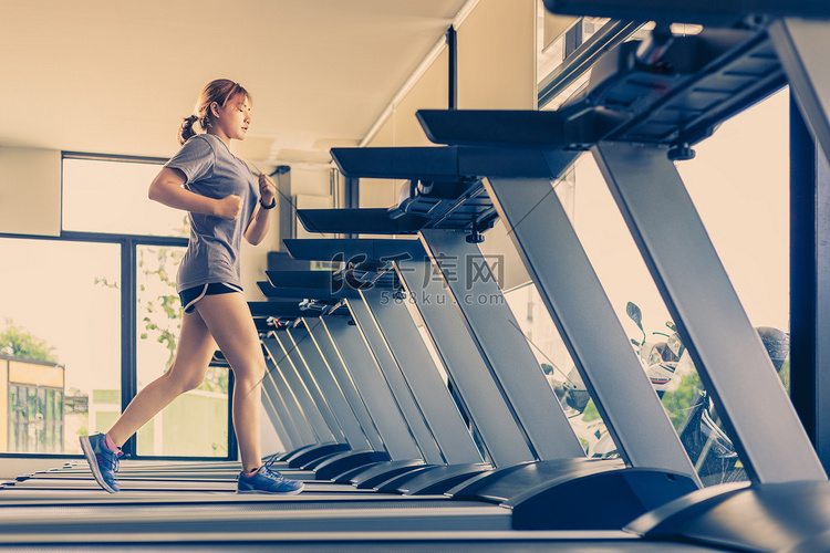 年轻的亚洲妇女在当地的健身房跑