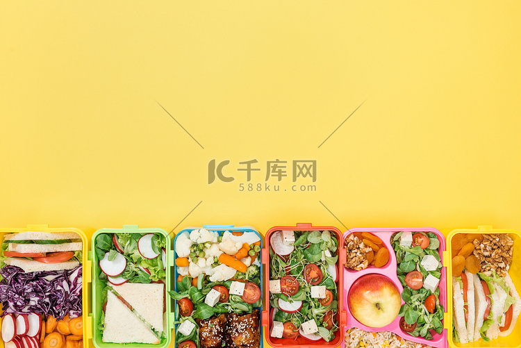 午餐盒的顶视图与食物在黄色背景