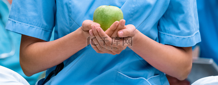 医学生手捧成熟绿色苹果的形象裁