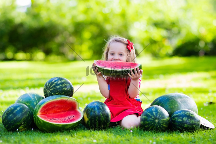 小女孩在花园里吃西瓜