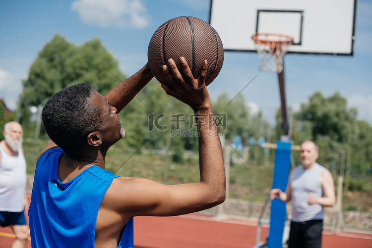 多种族老年人在操场上打篮球在夏