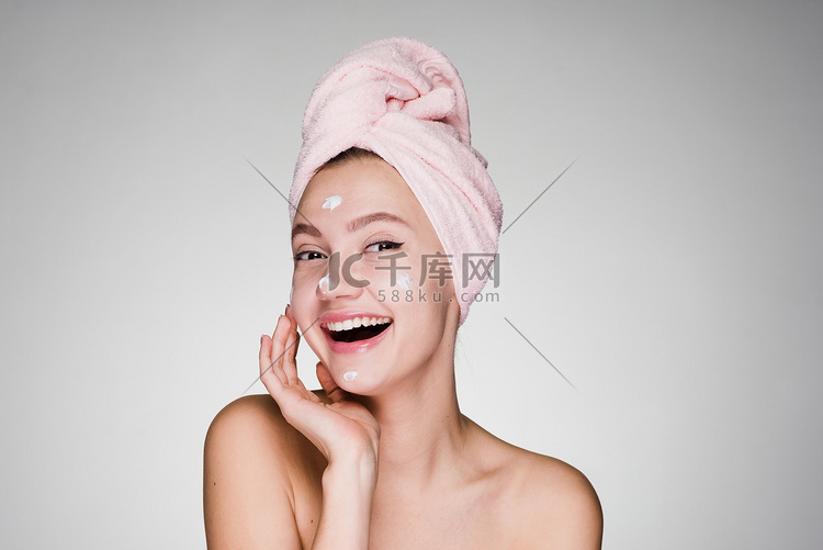 愉快的妇女用毛巾在她的头敷面霜