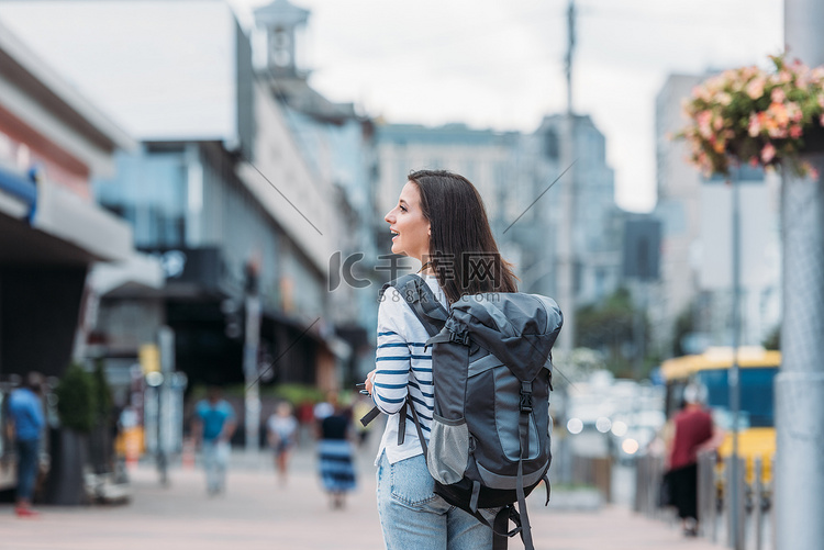 背着背包在街上行走的女人的后视