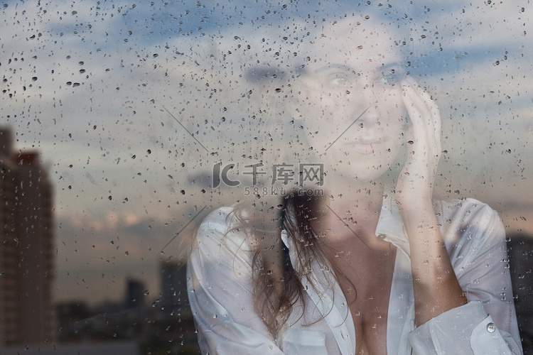 忧郁的女孩在窗口中的反映