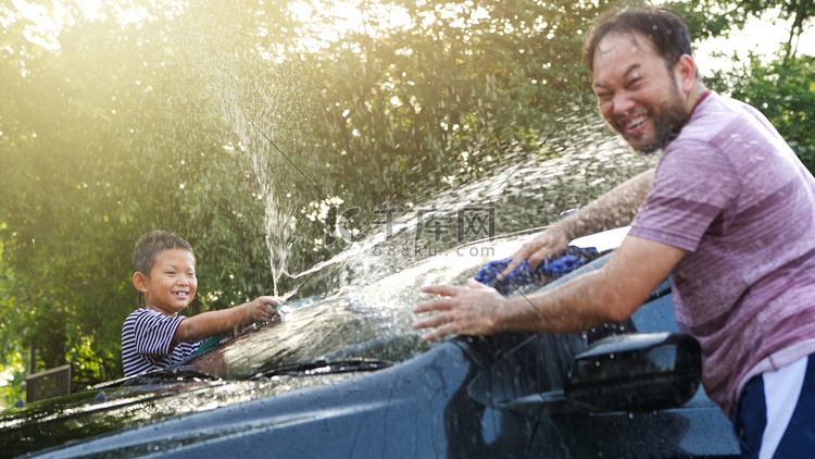 快乐的亚洲男孩帮助父母洗车的水
