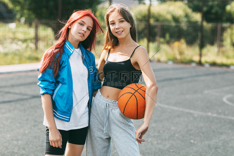 两个在运动场上打篮球的迷人女孩