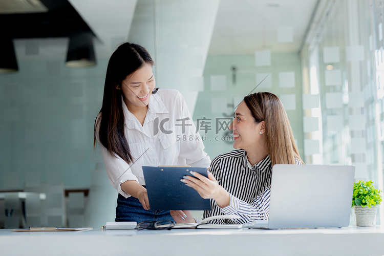 两名妇女正在研究笔记本电脑上的