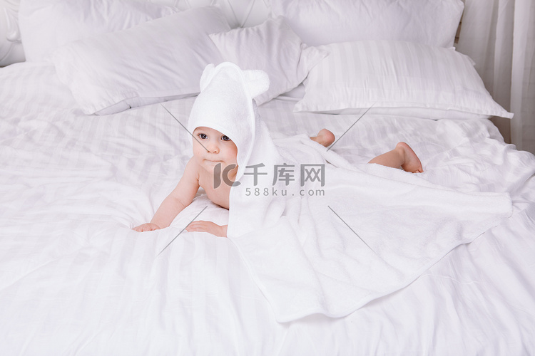婴儿躺在床上的白毛巾 ador