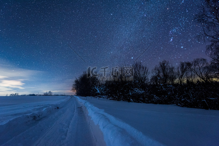 星罗黑的天空和雪天的道路在喀尔