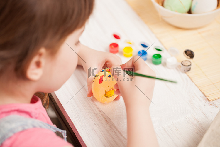女孩在家里的餐桌上画鸡蛋。