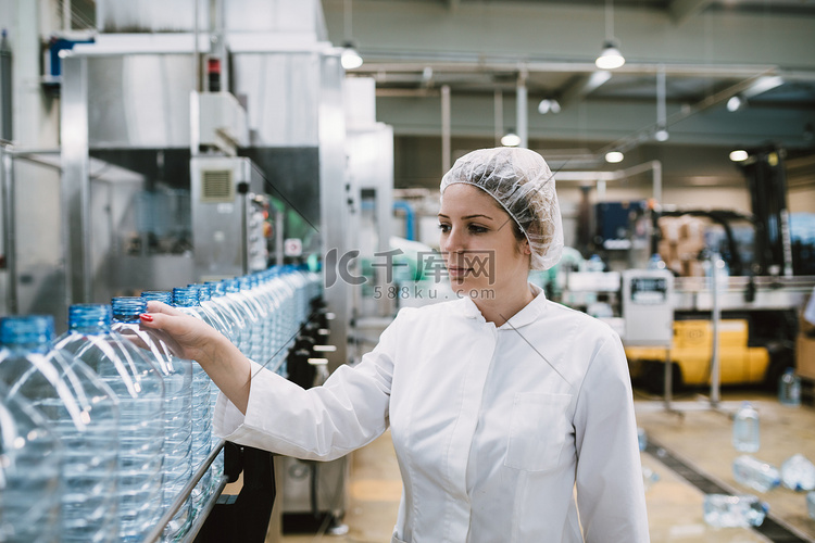 女工检查机器人生产线瓶装和包装