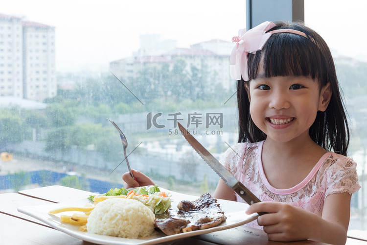 微笑亚洲中国小女孩吃羊肉牛肉饭