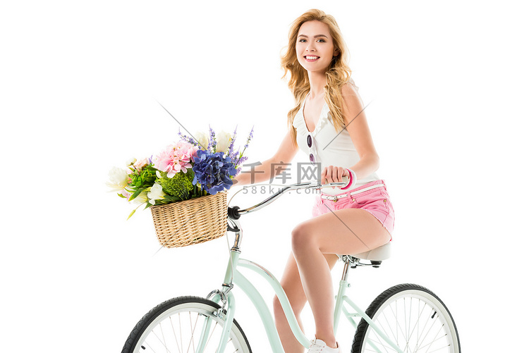有吸引力的年轻妇女骑自行车与花
