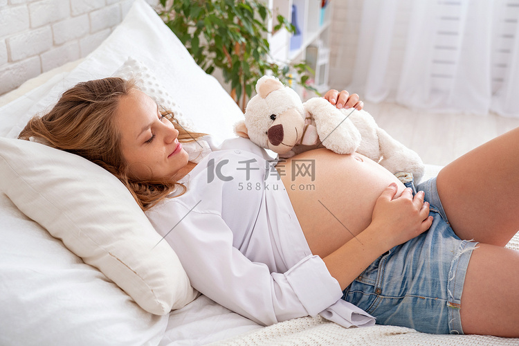 孕妇躺在床上躺着。摸她光溜溜的