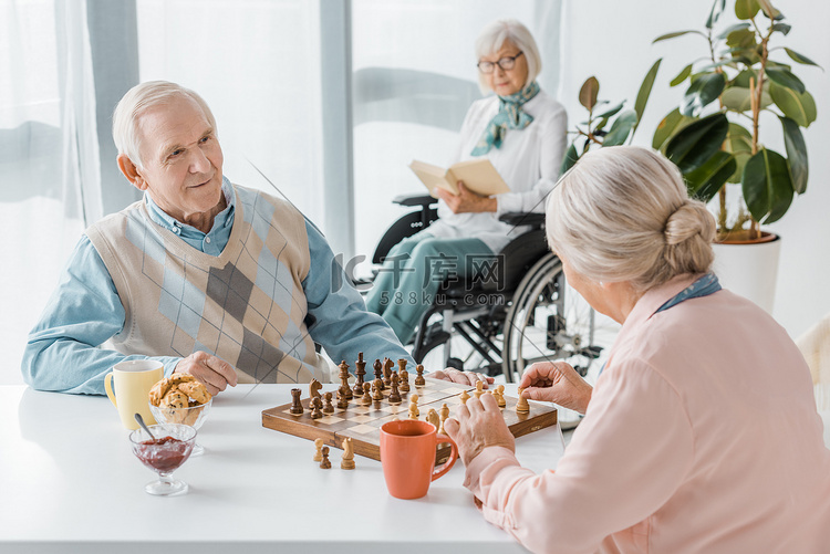 高级夫妇下棋, 而高级妇女坐在