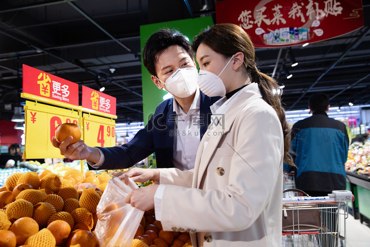 青年夫妇戴口罩在超市挑选水果