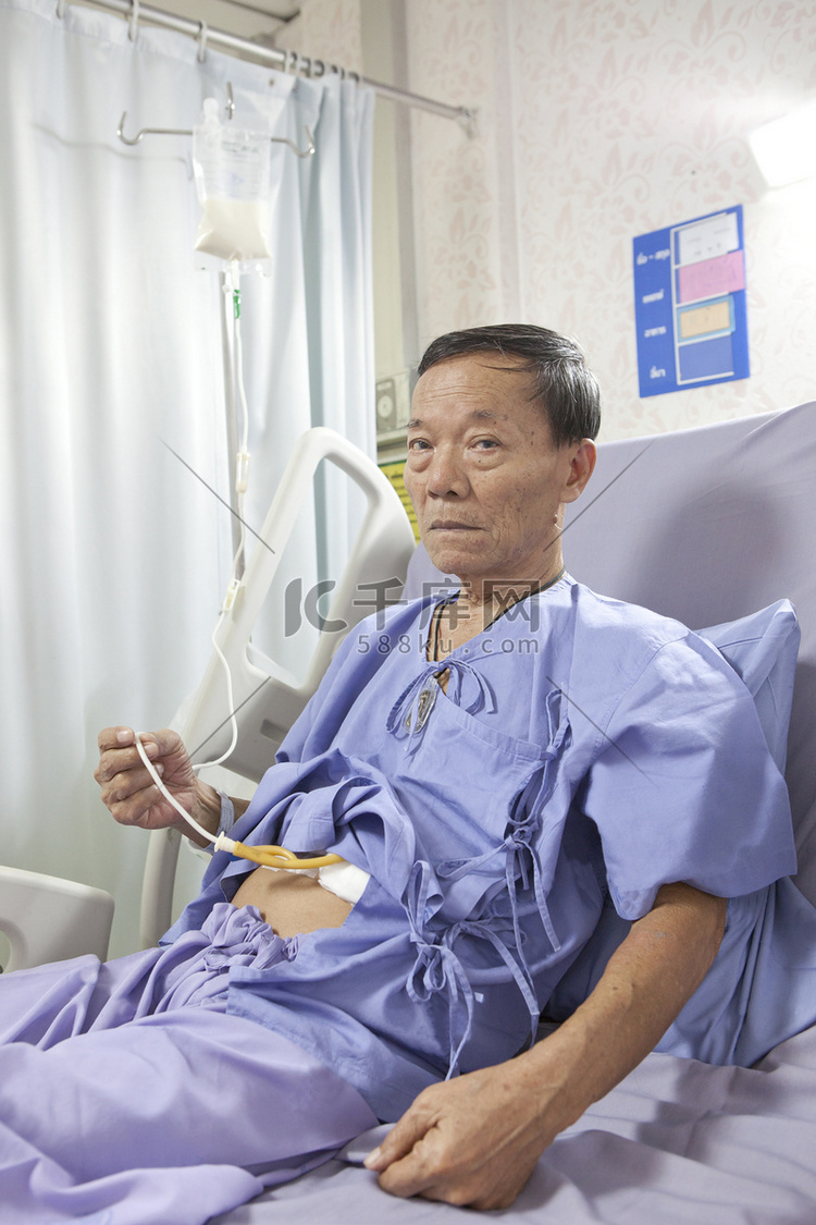 老人在医院的床上的病人喂食液态