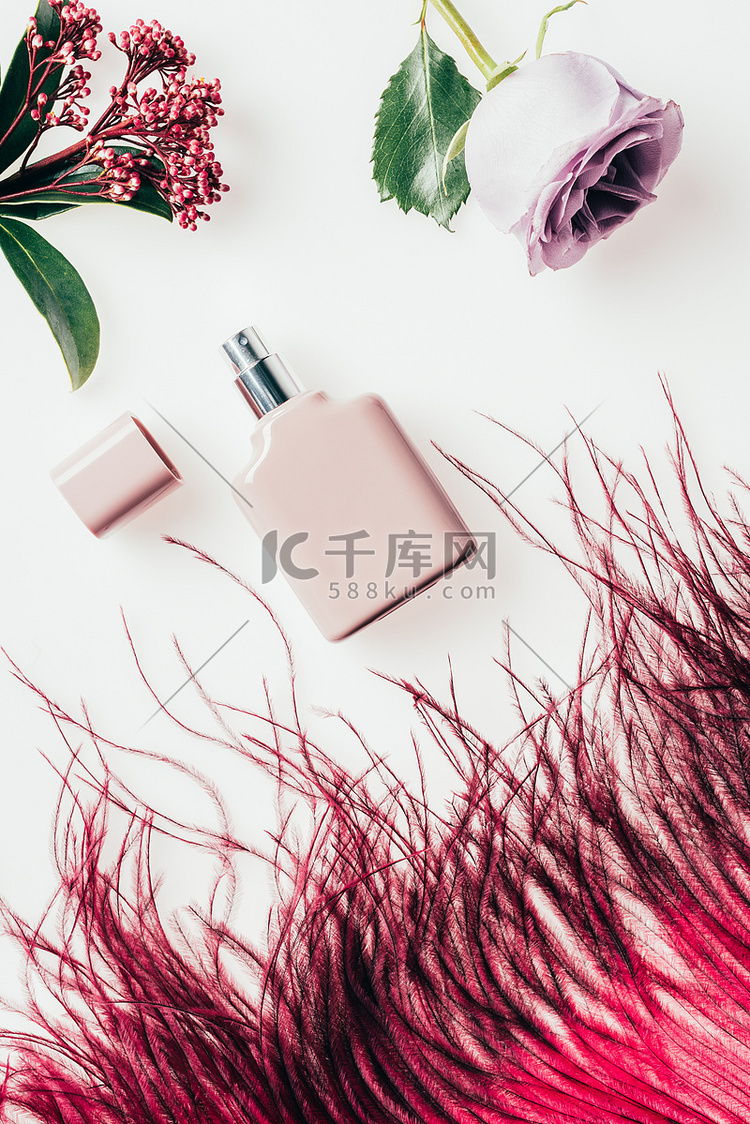 红色羽毛和白色花朵的香水瓶的顶