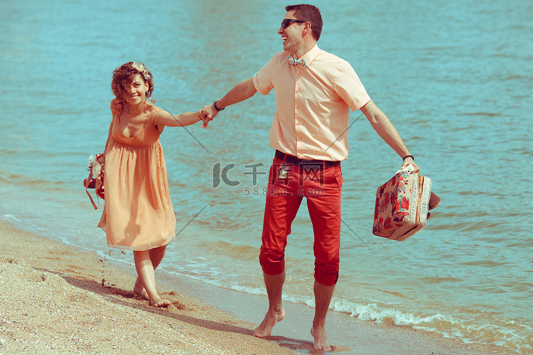 沙滩上散步的情侣。快乐的年轻人