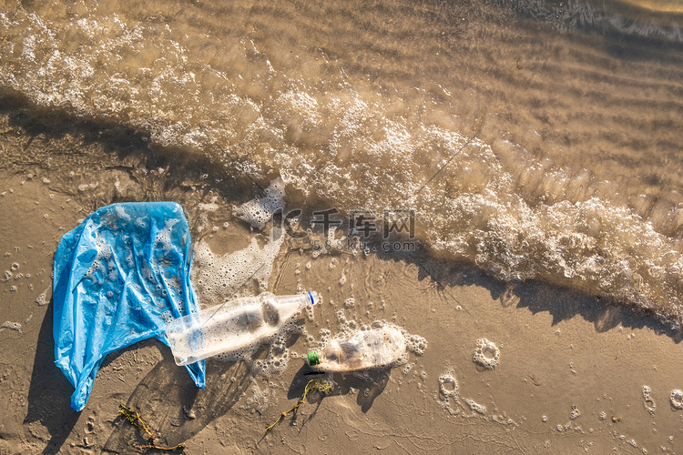 塑料袋和瓶子在海滩,海滨和水污