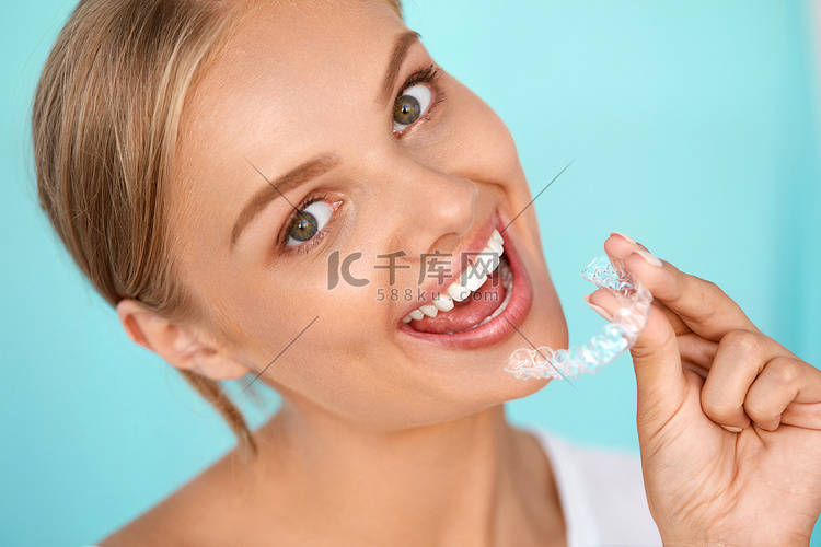 微笑的女人与白色牙齿举行牙齿美