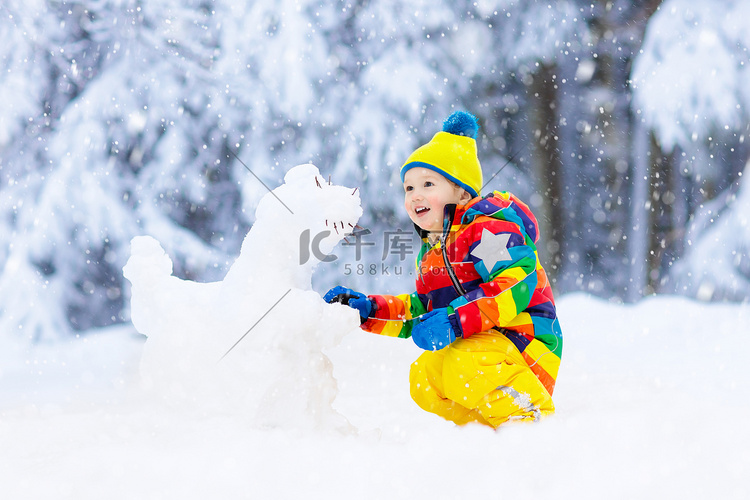 在雪冬公园里做雪人的孩子。孩子