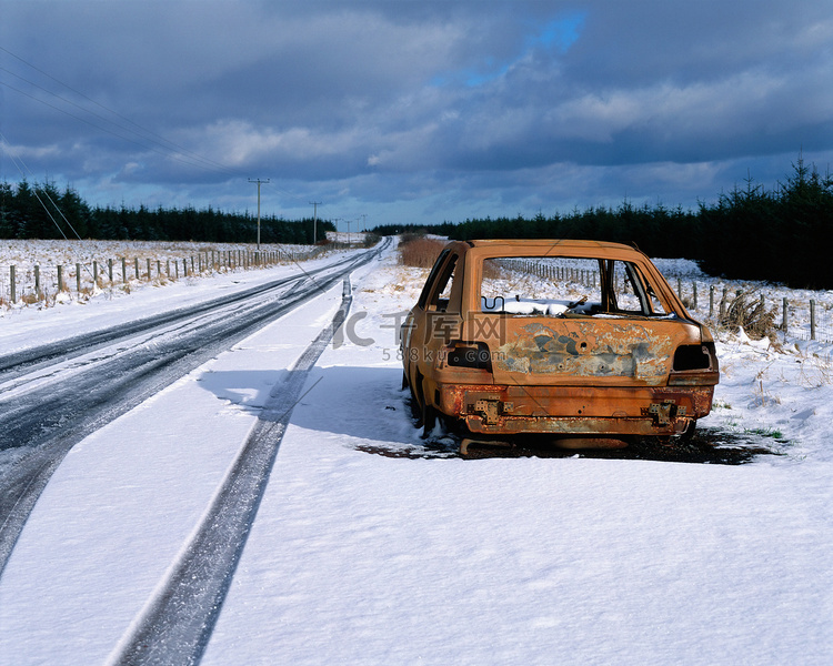 公路上被遗弃在雪地里的汽车