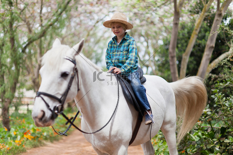 微笑的男孩在公园骑马