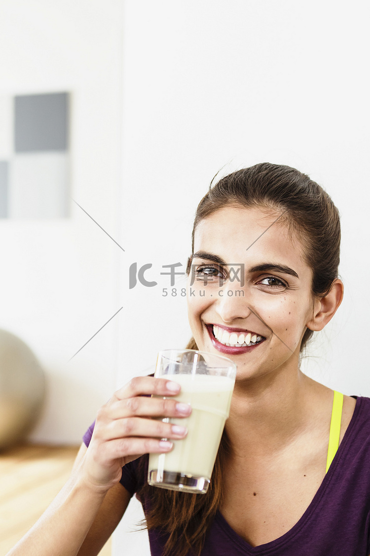 年轻女子在运动间隙喝果汁的肖像