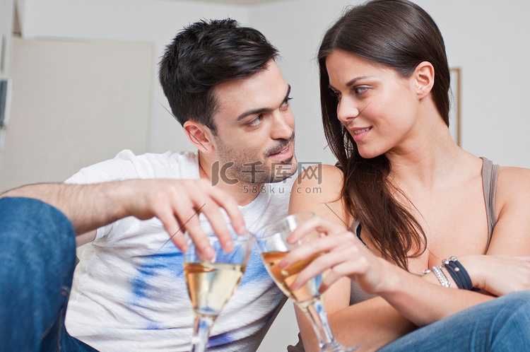 浪漫的年轻情侣共饮一杯葡萄酒