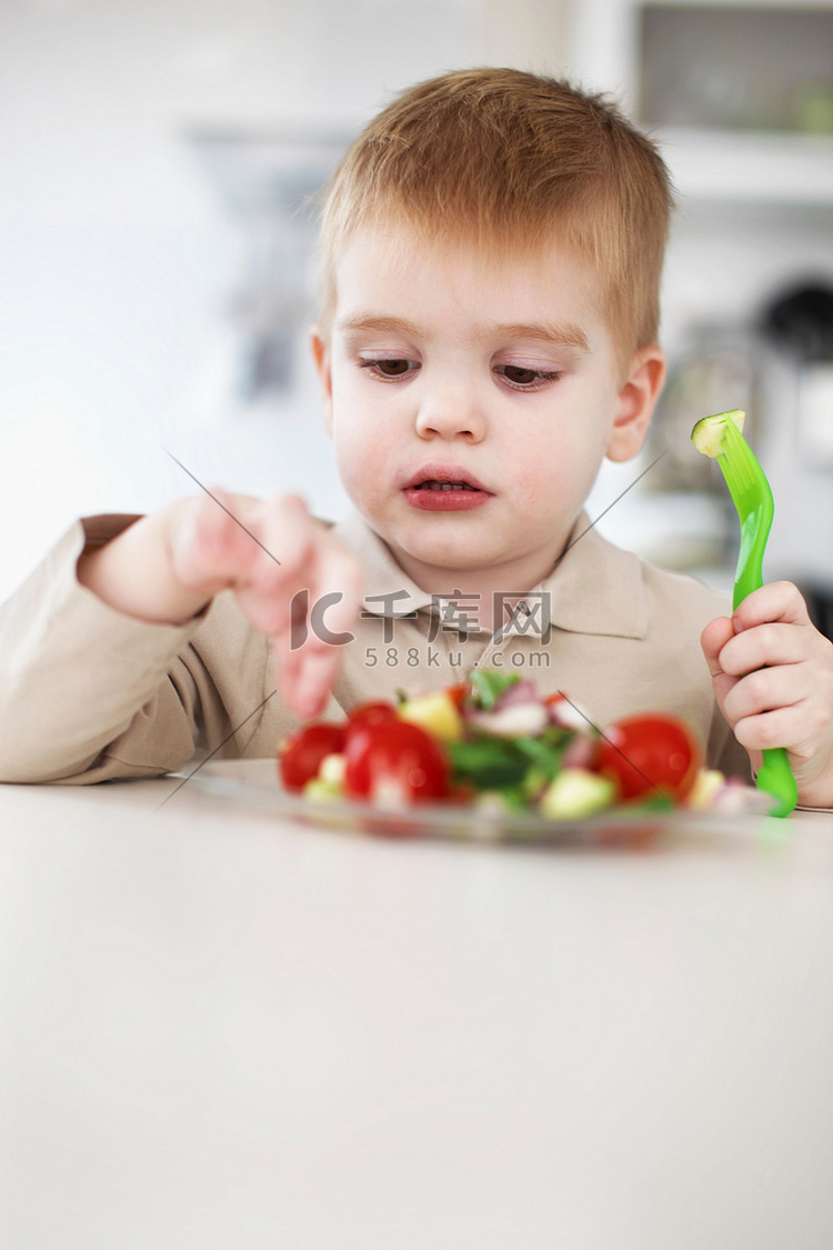 男孩在厨房里挑着一盘水果